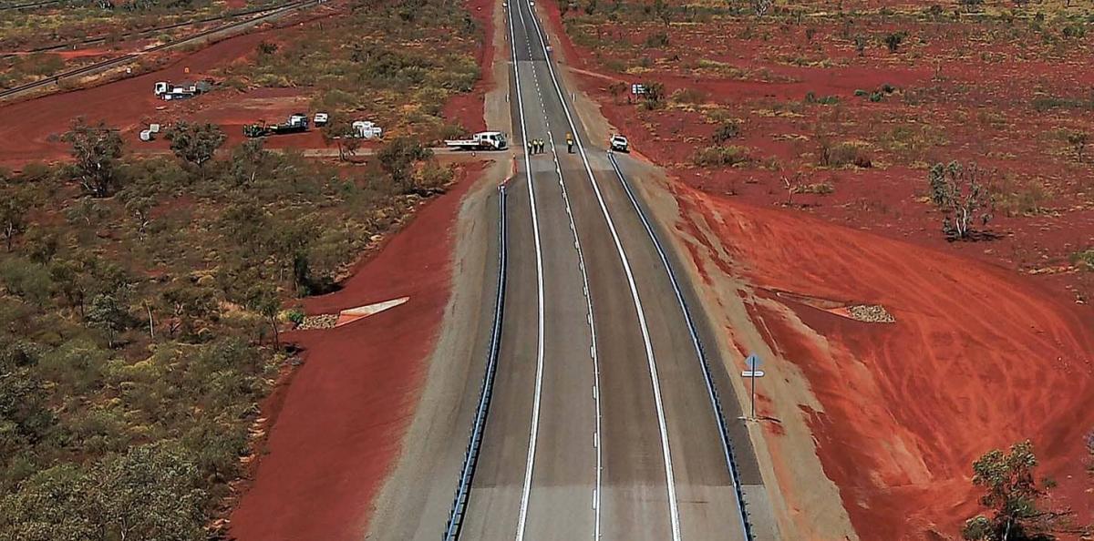 Aerial view of a highway with red dirt on either side