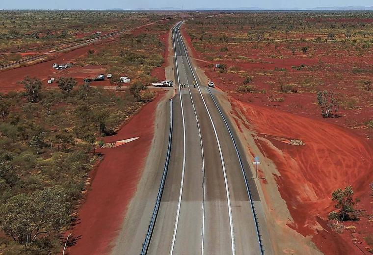Aerial view of a highway with red dirt on either side