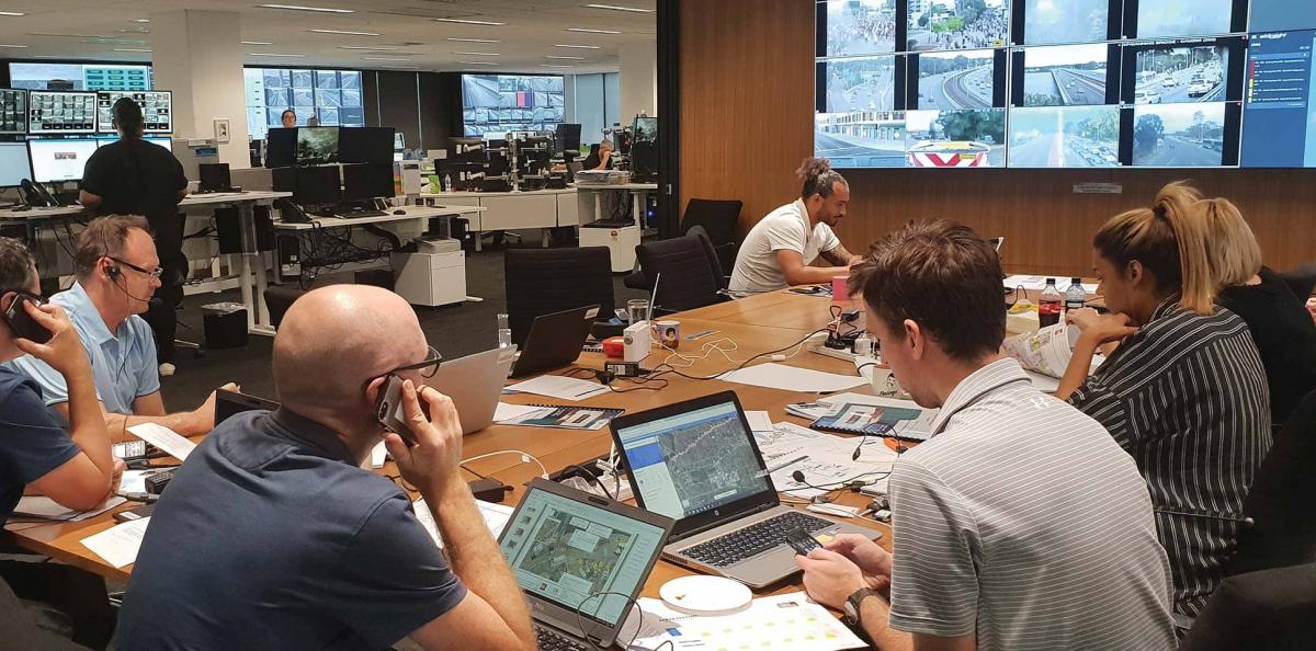 Team of workers at an office desk with laptops and phones