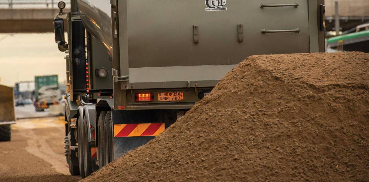 Rear view of a truck dumping a load of soil
