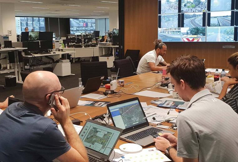 Team of workers at an office desk with laptops and phones